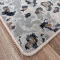 Load image into Gallery viewer, Close-up of the edge binding on the Dire Leopard Hide Rug, showing durable stitching and detailed faux leopard print for fantasy-themed and game room interiors.
