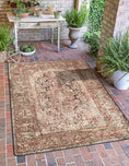 Load image into Gallery viewer, The Ravencourt Rug on a shaded portico, lending antique drama and shadowy elegance to the outdoor entryway.