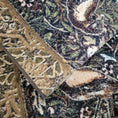 Load image into Gallery viewer, The Secret Garden rug shown folded to reveal its moss-toned yarn, floral pattern, and detailed weaving