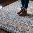 Load image into Gallery viewer, Close-up of a girl’s feet standing on The Weaver’s Medallion rug, highlighting the texture and gentle hues of sage, blue, and rose