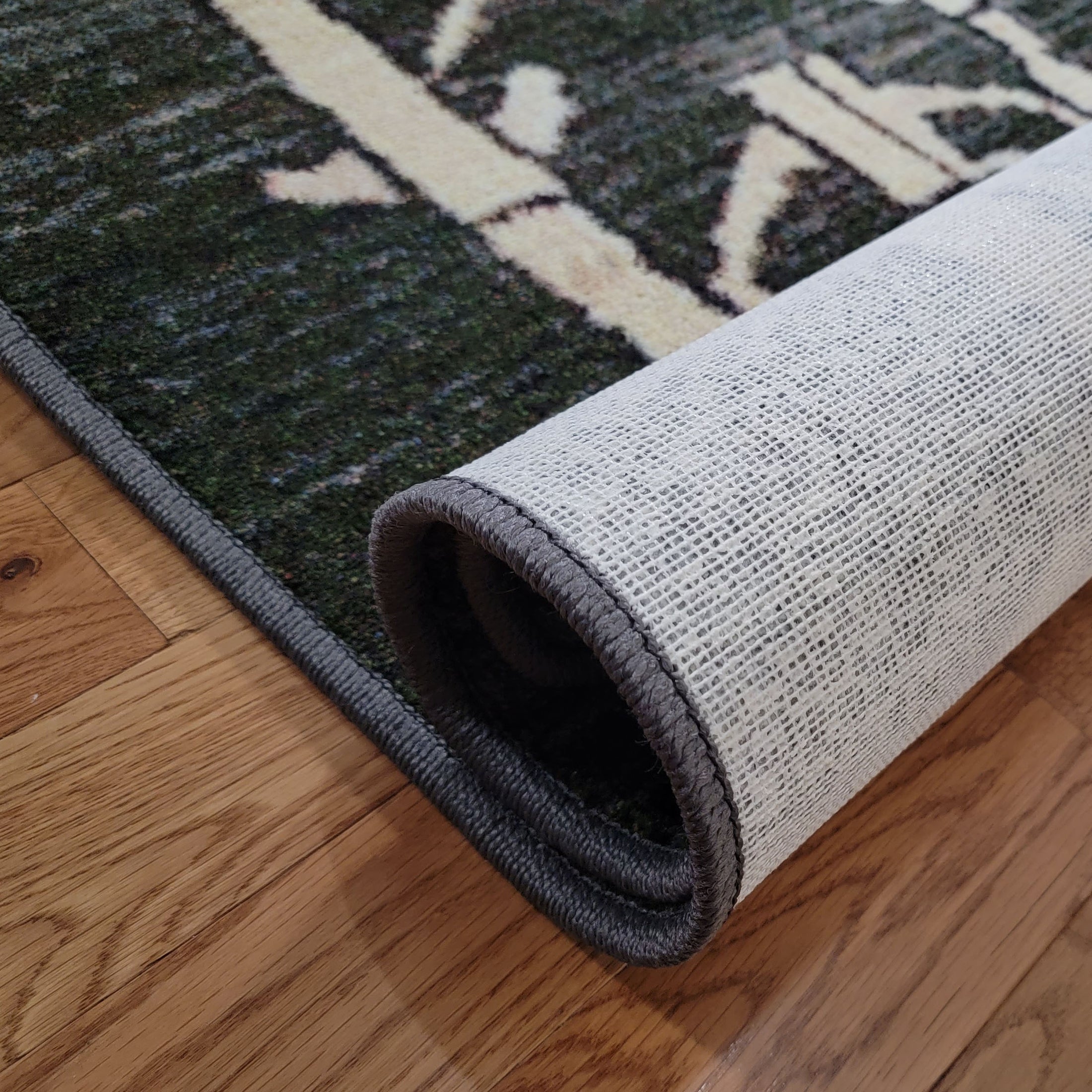 Detail of Arcade Hunter rug’s synthetic Loc-Bak backing, designed for durability and long-lasting flatness in high-traffic areas.