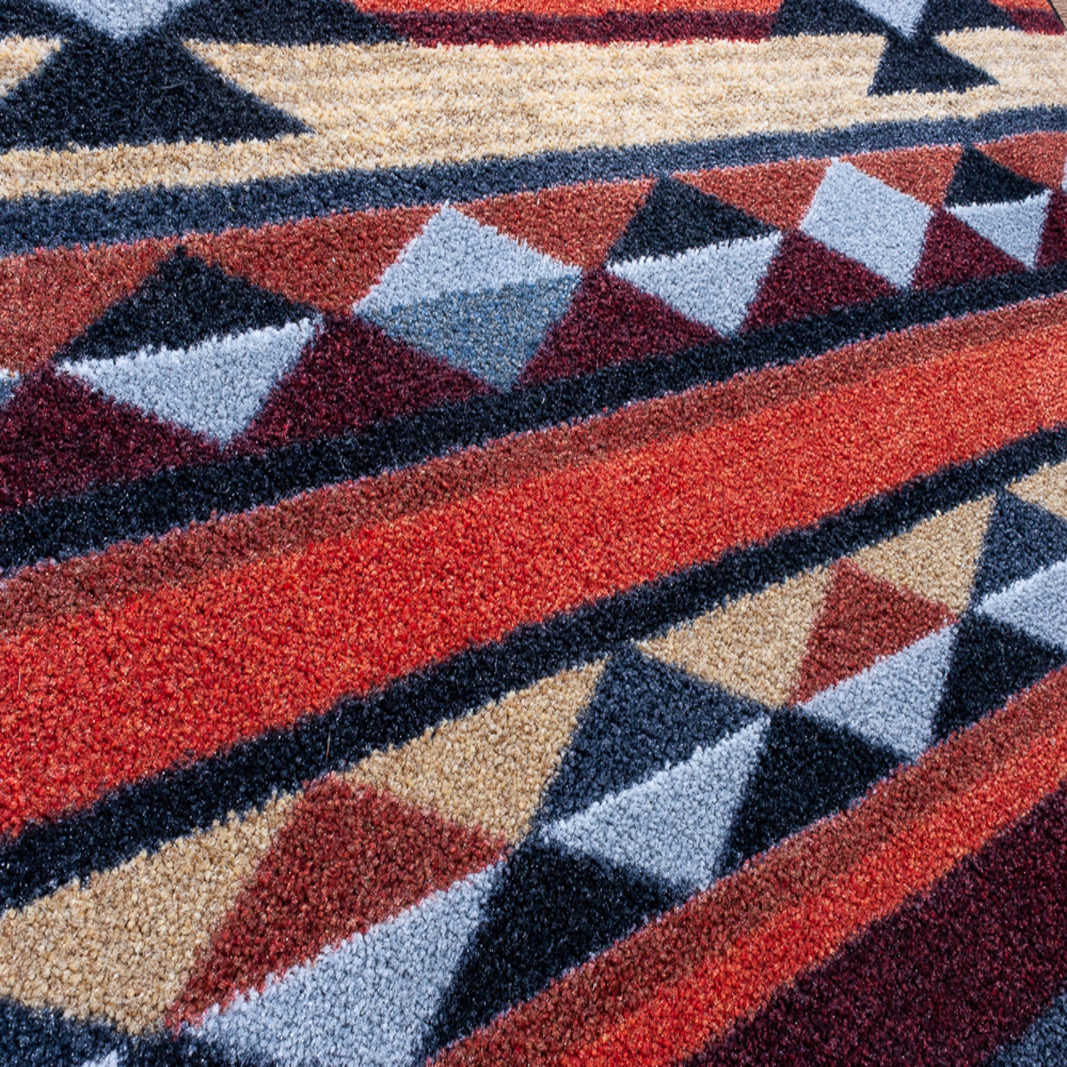 Extreme close-up of the Ashspire Ridge rug yarn showing the dense weave and rich color texture in desert-inspired tones

