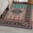 Load image into Gallery viewer, The Dreamcrafter’s Medallion rug placed in a cozy reading nook, highlighting its vibrant ombré fade and intricate medallion details in plum, amber, and jade tones


