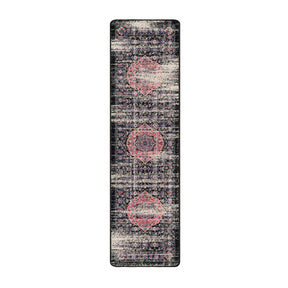 2x8 runner of The Floromancer’s Medallion rug featuring elongated floral scrollwork in pink against a faded black background

