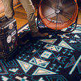 Load image into Gallery viewer, The Four Tides Rug in a studio room, bringing the mystery and power of the ocean into a contemporary living space with its deep blue design.
