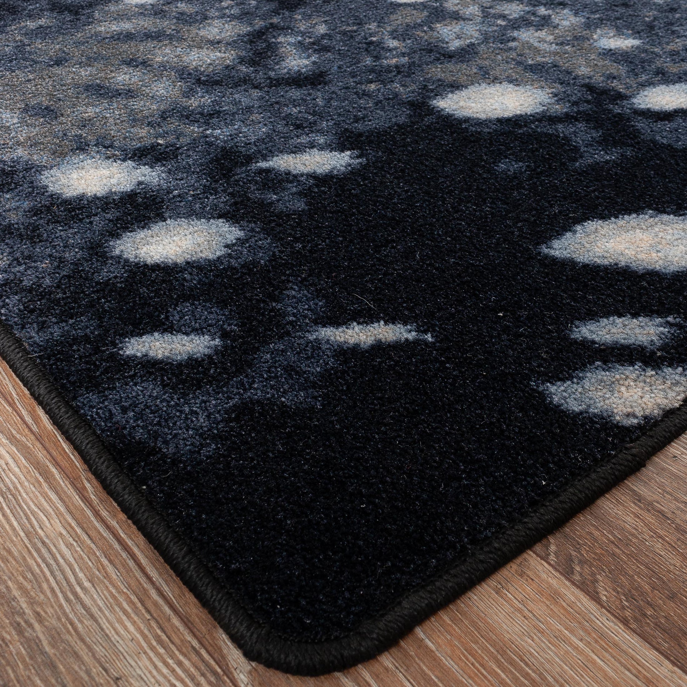 Detailed shot of the Nocturna’s Hide rug corner, showing clean edging and the organic spotted pattern along the border

