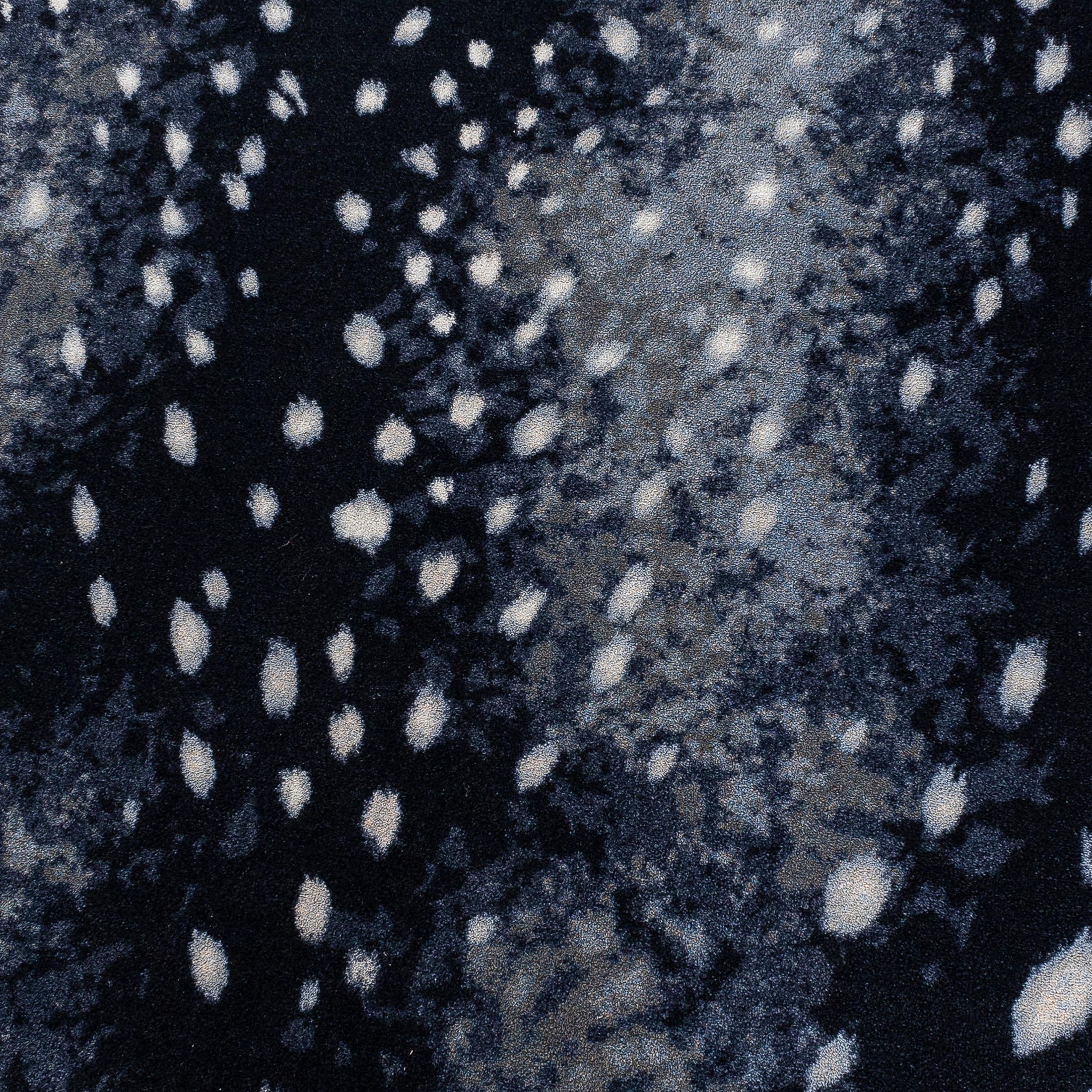 Close-up view of Nocturna’s Hide rug pattern, showing scattered moonlight-like spots against a black and navy background
