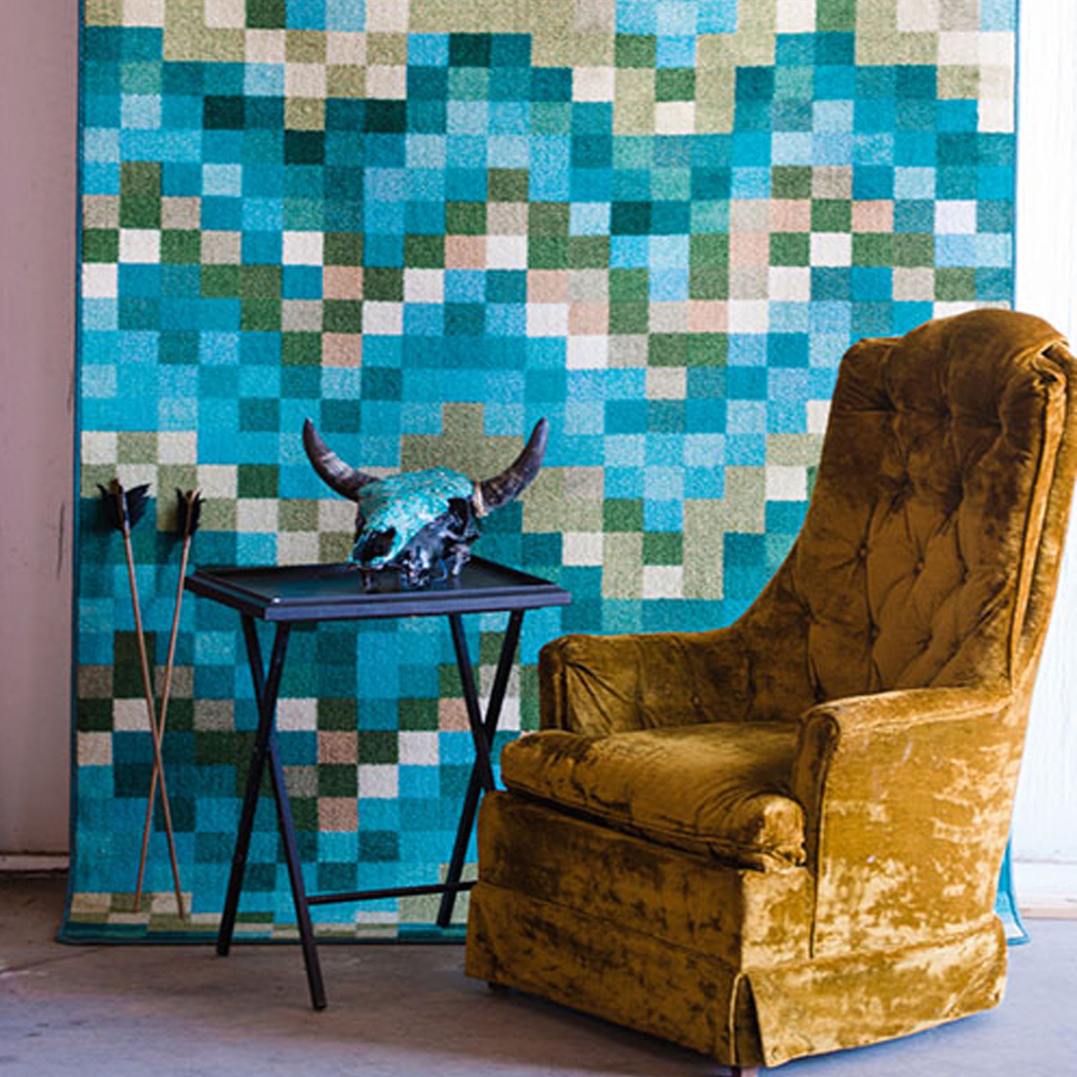 Marketing scene featuring The Pixel Pool rug hanging vertically in the background with an antique chair in front, showcasing its bold pixelated wave pattern in a stylish, editorial setup

