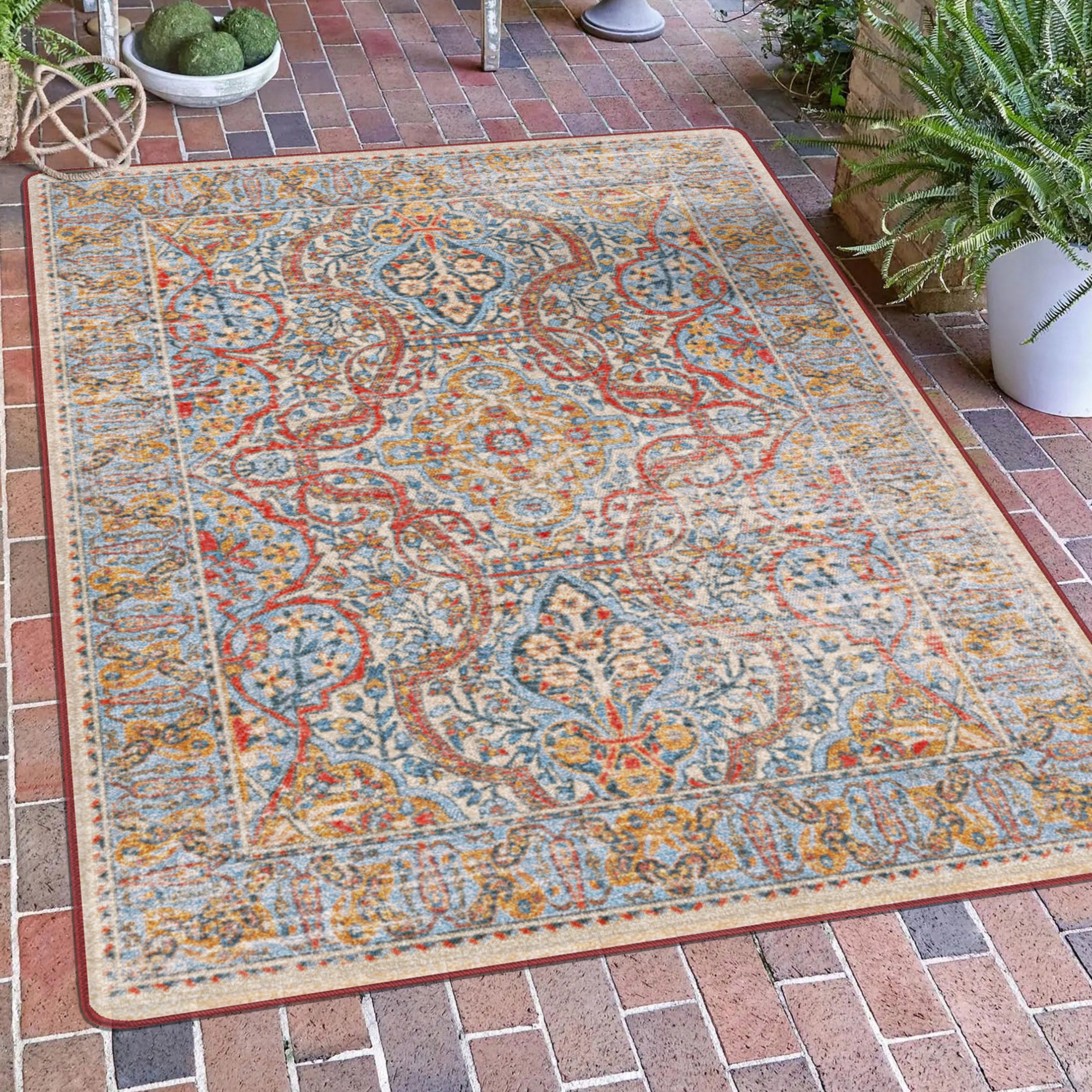 The Redreach Rug styled in a sunlit portico, with bold crimson medallions and golden accents adding warmth and ceremony to the outdoor-inspired space