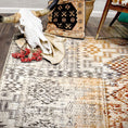 Load image into Gallery viewer, Close-up of the Sandveil Map rug styled with a decorative steer skull, striped cloth, and a tribal woven pillow.
