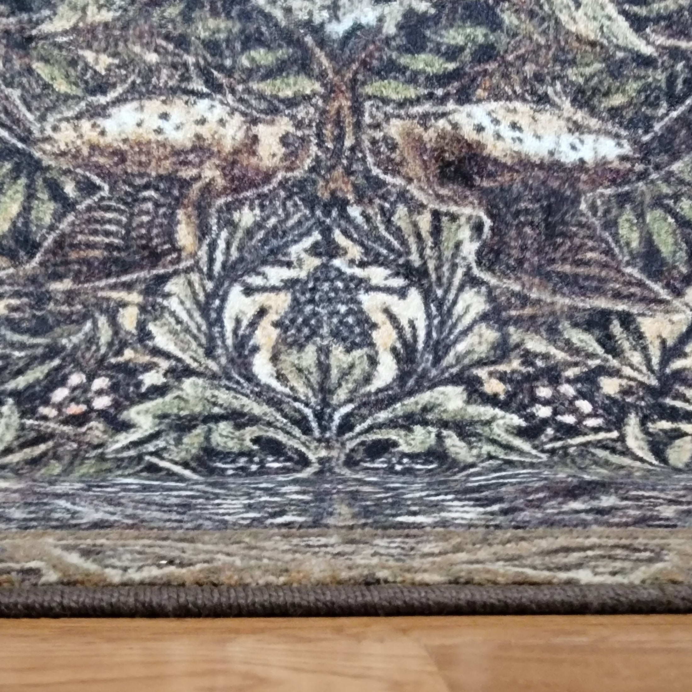 Edge of The Secret Garden rug showcasing its strong stitching and bordered woodland motif