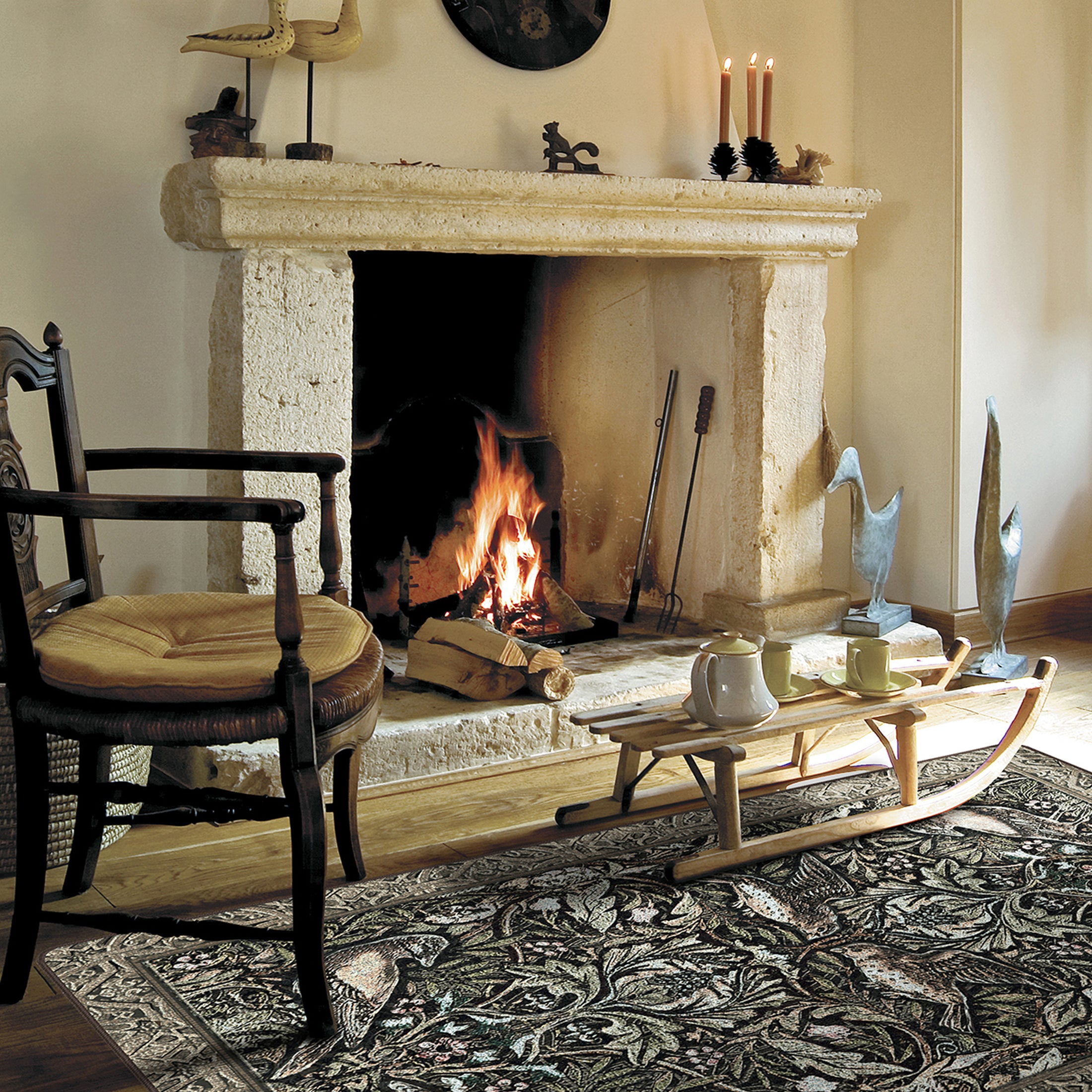 The Secret Garden rug styled in a vintage living room with mossy green tones, intricate floral and bird design, and an ornate forest-inspired layout