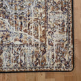 Load image into Gallery viewer, Close-up of The Wildroot Rug’s corner with weathered  brown and cream edgework and intricate floral pattern
