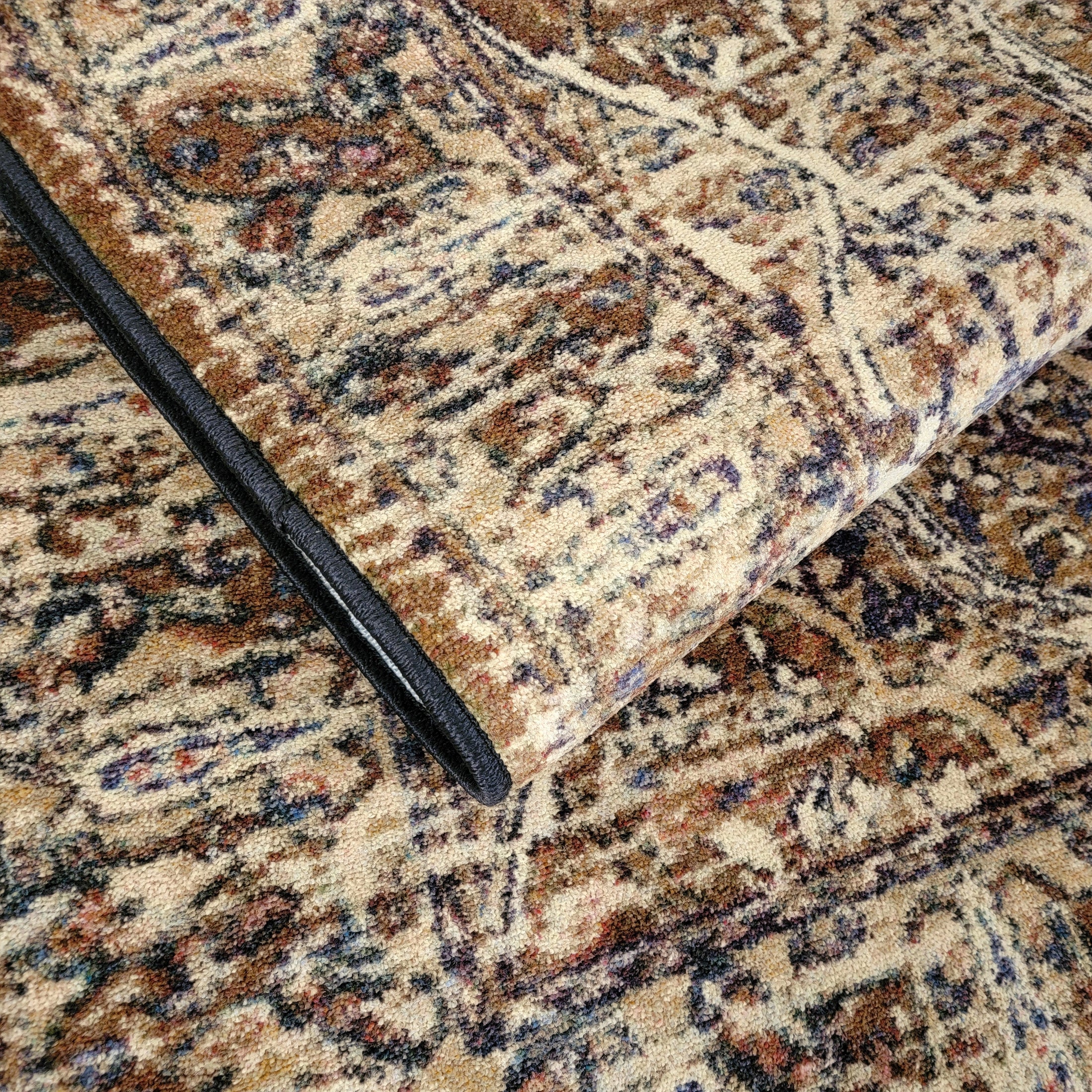 Close-up of a patterned rug with a black object on top