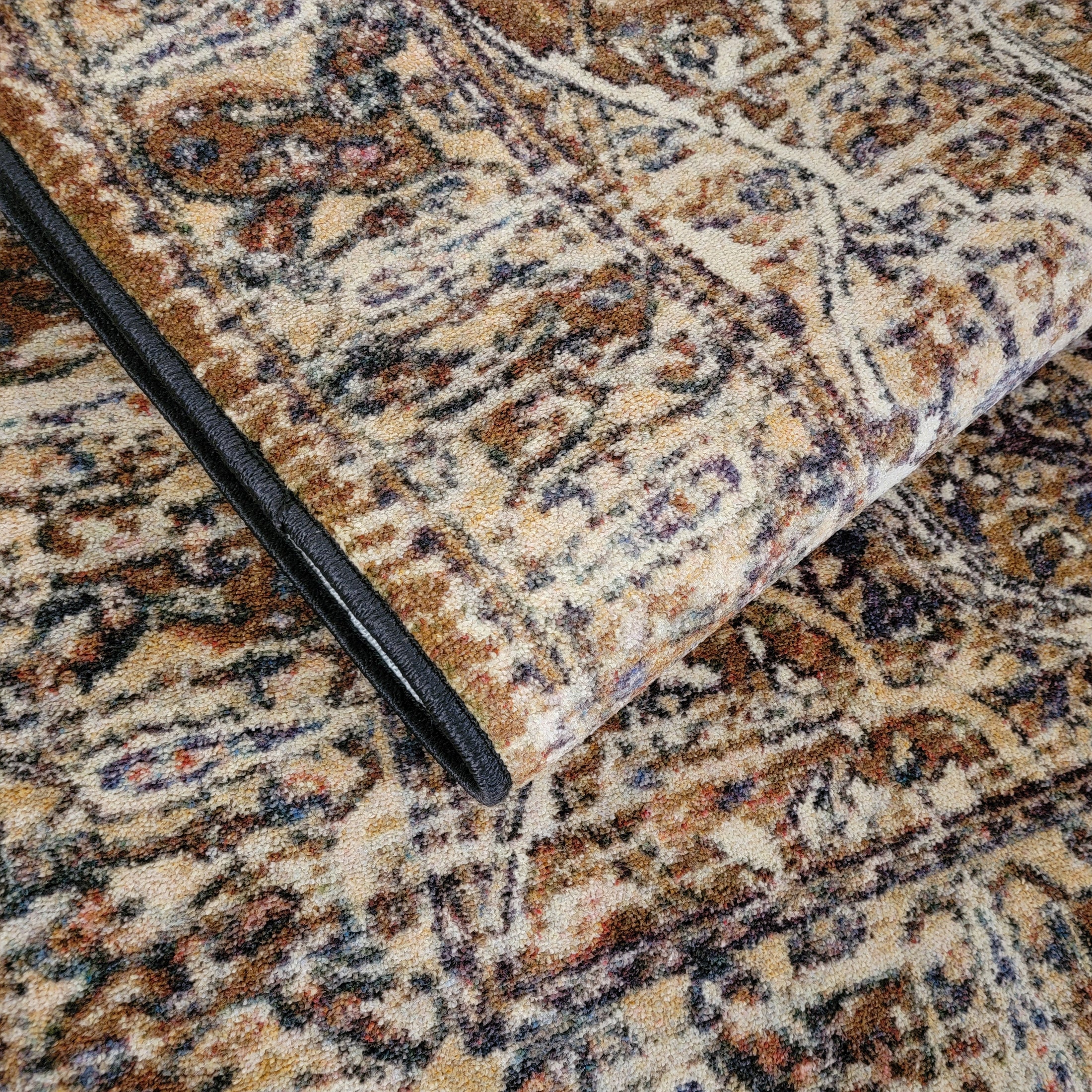The Wildroot Rug folded to show layered texture and pattern, with visible purple and ash hues